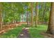 Beautiful backyard with lush greenery, mature trees, and a serene pathway leading to the lake at 7530 Heard Rd, Cumming, GA 30041