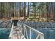 The backyard includes stairs to the lake and bridge, with mature trees at 7530 Heard Rd, Cumming, GA 30041