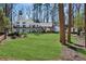 Backyard and deck with lush green grass, well-manicured landscaping, and a covered deck area at 7530 Heard Rd, Cumming, GA 30041