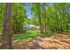 Lush backyard with mature trees offering privacy, showcasing the expansive lawn and the home's exterior at 7530 Heard Rd, Cumming, GA 30041