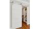 Stylish barn door with modern hardware, leading to a staircase and storage shelves at 7530 Heard Rd, Cumming, GA 30041