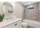 Elegant bathroom with a marble vanity, round mirror, and a shower-tub combo at 7530 Heard Rd, Cumming, GA 30041