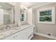 Bright bathroom with double vanity, granite countertops, and a large window with natural light at 7530 Heard Rd, Cumming, GA 30041