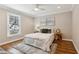 Cozy bedroom featuring hardwood floors, a large window, and neutral decor at 7530 Heard Rd, Cumming, GA 30041