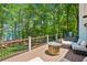Spacious deck with a stone fire pit, grill, lounge furniture, and tranquil views of the lake at 7530 Heard Rd, Cumming, GA 30041