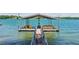 Dock featuring a sun deck, wooden chairs, and boat storage on a tranquil lake at 7530 Heard Rd, Cumming, GA 30041