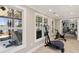 Home gym features an elliptical trainer, exercise bike, and hot tub overlooking the lake at 7530 Heard Rd, Cumming, GA 30041