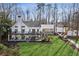Rear exterior showcasing the manicured lawn, back patio, and multi-story deck and porch at 7530 Heard Rd, Cumming, GA 30041