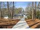 Long driveway leading to a beautiful white home with a portico and well-maintained landscape at 7530 Heard Rd, Cumming, GA 30041