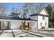 Lake home featuring a charming portico with wood columns connecting the house and garage at 7530 Heard Rd, Cumming, GA 30041