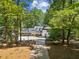 Charming two-story home featuring white siding, black trim, and a drive-through portico amidst lush greenery at 7530 Heard Rd, Cumming, GA 30041