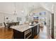 Open-concept kitchen with granite island, hardwood floors, and stainless steel appliances at 7530 Heard Rd, Cumming, GA 30041