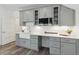Kitchenette with gray cabinets, stainless steel microwave, white farmhouse sink and quartz countertops at 7530 Heard Rd, Cumming, GA 30041