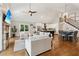 Open concept living room with hardwood floors, stone fireplace, staircase, and views of the kitchen and dining area at 7530 Heard Rd, Cumming, GA 30041