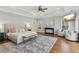 Serene primary bedroom featuring a tray ceiling, cozy seating area, and a plush rug on hardwood floors at 7530 Heard Rd, Cumming, GA 30041