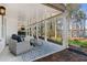 Covered porch featuring lounge seating and a hot tub overlooking the wooded backyard and lake at 7530 Heard Rd, Cumming, GA 30041