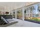 Covered patio featuring lounge seating overlooking a wooded yard with lake views at 7530 Heard Rd, Cumming, GA 30041
