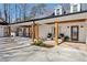 Inviting portico with wooden columns, stone patio, and comfortable seating area near the main entrance at 7530 Heard Rd, Cumming, GA 30041