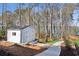 White shed with double doors situated by the lake with a view and walking path at 7530 Heard Rd, Cumming, GA 30041