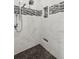 Beautiful walk-in shower featuring marble tiling, mosaic accents, and sleek fixtures at 7530 Heard Rd, Cumming, GA 30041