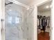 Bathroom featuring a glass enclosed marble-tiled shower and a peek into the walk-in closet at 1012 Rohner Way, Smyrna, GA 30080