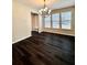 Bright dining area with chandelier lighting, large windows, and beautiful hardwood floors at 4316 Waxwing St, Buford, GA 30548