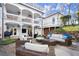 Expansive outdoor patio features wicker furniture with plush seating, and a white two-story home with covered balconies at 6170 Wellington Ct, Cumming, GA 30040