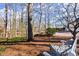 Landscaped backyard with seating area, mature trees, and plush pine straw at 6170 Wellington Ct, Cumming, GA 30040