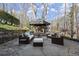 Outdoor patio with wicker furniture and a gazebo is surrounded by mature trees in a landscaped yard at 6170 Wellington Ct, Cumming, GA 30040