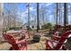 A backyard fire pit with Adirondack chairs overlooks a lovely home at 6170 Wellington Ct, Cumming, GA 30040