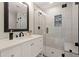 Bright bathroom featuring a glass shower, mosaic tile accents, and a white vanity with a dark-trimmed mirror at 6170 Wellington Ct, Cumming, GA 30040