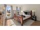 Comfortable bedroom featuring a classic wood bed frame, soft rug, and plentiful natural light from two large windows at 6170 Wellington Ct, Cumming, GA 30040