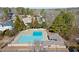 Areal view of a community pool that is rectangular in shape surrounded by trees, homes, and a pool house at 6170 Wellington Ct, Cumming, GA 30040