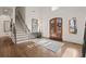 Bright and airy foyer with wood floors, staircase, and large arched double doors for a grand entrance at 6170 Wellington Ct, Cumming, GA 30040