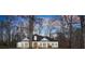 Beautiful home surrounded by mature trees and a colorful sunset, providing a serene and private setting at 6170 Wellington Ct, Cumming, GA 30040