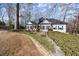 Inviting single-story home with a stone retaining wall, garden beds, and an American flag waving by the entrance at 6170 Wellington Ct, Cumming, GA 30040