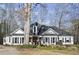 Charming single-story home boasts a well-maintained front yard, complemented by a stone wall and mature trees at 6170 Wellington Ct, Cumming, GA 30040