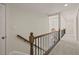 Bright hallway with carpet flooring, elegant railings, and neutral paint, connecting various rooms in the home at 6170 Wellington Ct, Cumming, GA 30040