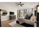 Elegant main bedroom with natural light, a ceiling fan, dresser with television, and hardwood floors at 6170 Wellington Ct, Cumming, GA 30040