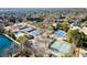 Aerial view of multiple blue tennis courts surrounded by lush trees and a serene lake in a vibrant community at 6170 Wellington Ct, Cumming, GA 30040