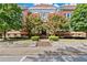 Brick building exterior featuring beautiful landscaping, including trees with pink flowers, and a classic stone facade at 978 North Ne Ave # 307, Atlanta, GA 30306