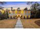 Elegant two-story home with a symmetrical facade, warm exterior lighting, and a well-maintained front lawn at 4132 Carmain Ne Dr, Atlanta, GA 30342