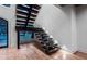 Modern staircase with wood and glass elements, illuminated treads and hardwood floors at 4132 Carmain Ne Dr, Atlanta, GA 30342