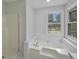 Clean bathroom featuring a shower and tub combo, and a soaking tub with a view of the deck at 9035 Teal Ln, Jonesboro, GA 30236