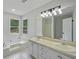 Bright bathroom featuring a soaking tub, double vanity, and a large mirror with modern lighting at 9035 Teal Ln, Jonesboro, GA 30236