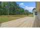 Large wooden deck with wood railing overlooking a spacious green lawn and many mature trees at 9035 Teal Ln, Jonesboro, GA 30236