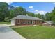 Classic brick home with an attached garage and a long driveway, showcasing its curb appeal at 9035 Teal Ln, Jonesboro, GA 30236