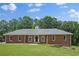 Charming brick home with a well-manicured lawn, beautiful trees, and a classic design at 9035 Teal Ln, Jonesboro, GA 30236