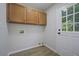 Well-lit laundry room featuring wood cabinets and a door leading to the outside at 9035 Teal Ln, Jonesboro, GA 30236