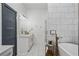 Bright bathroom with white tile floors, marble tile shower, and a freestanding bathtub with gold fixtures at 1171 Eggleston Sw St, Atlanta, GA 30310